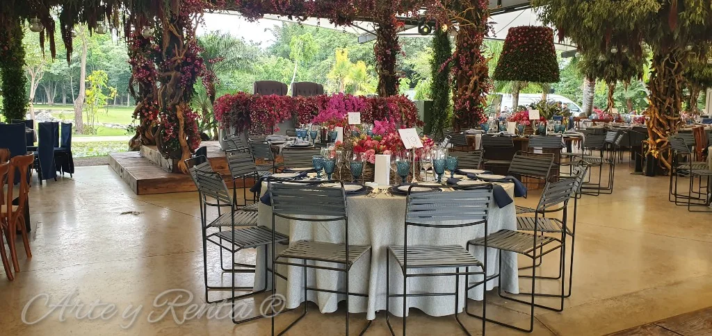 Montaje de banquete con sillas oscuras y decoración floral