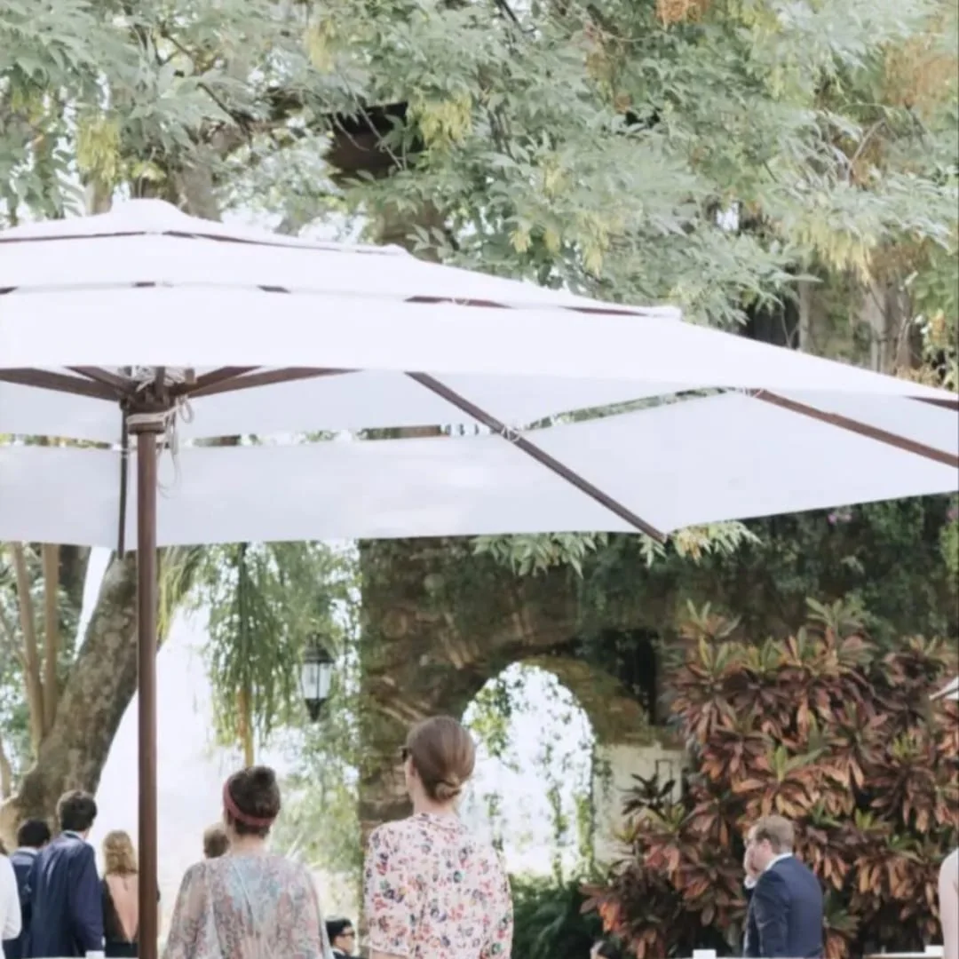 Sombrillas blancas para recepción de boda en jardín